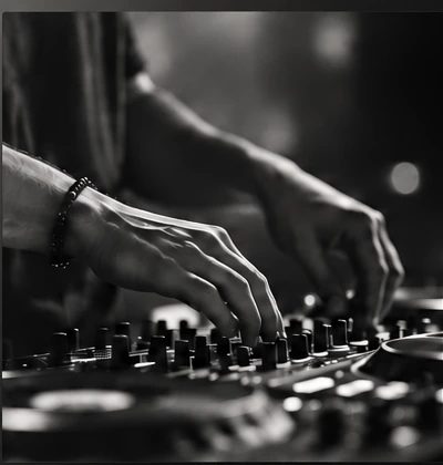 Les mains d'un DJ sur une table de mixage, en noir et blanc